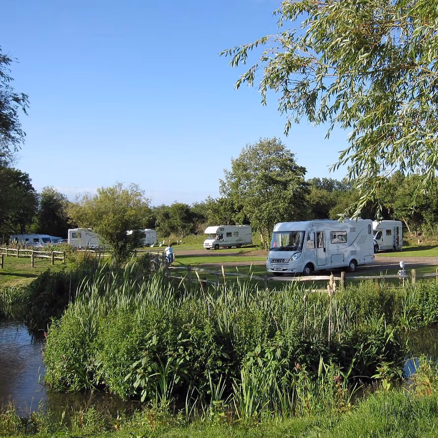 Touring caravan park with lake in foreground