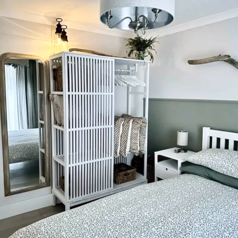 A green bedroom with white furniture