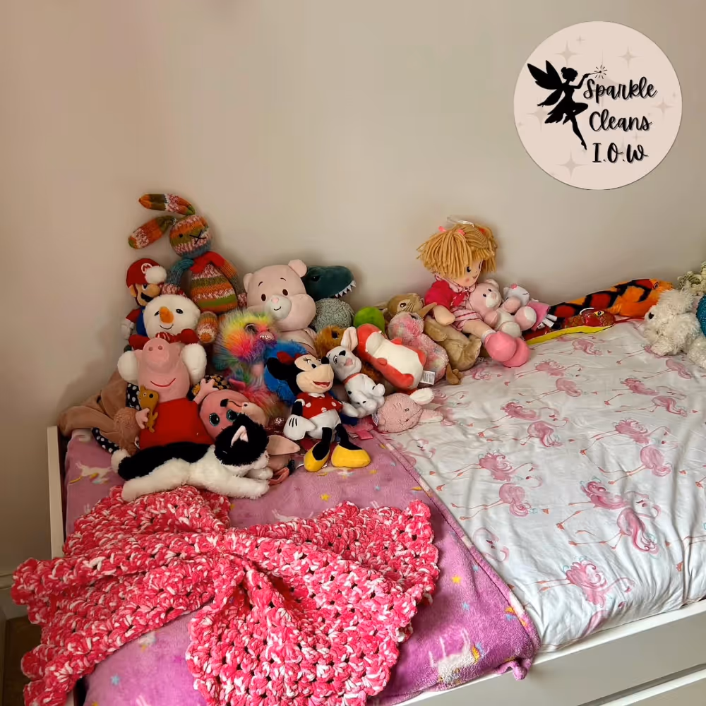 Teddies and toys arranged on a child's bed
