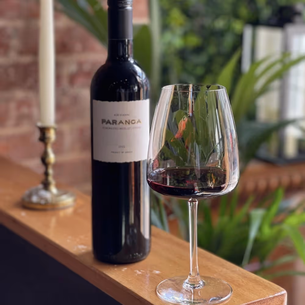 A bottle of red wine and a wine glass