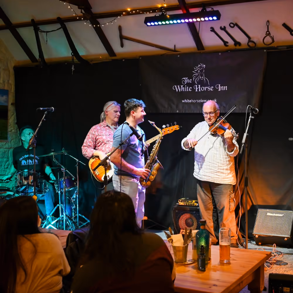 3 musicians playing on a stage in a pub