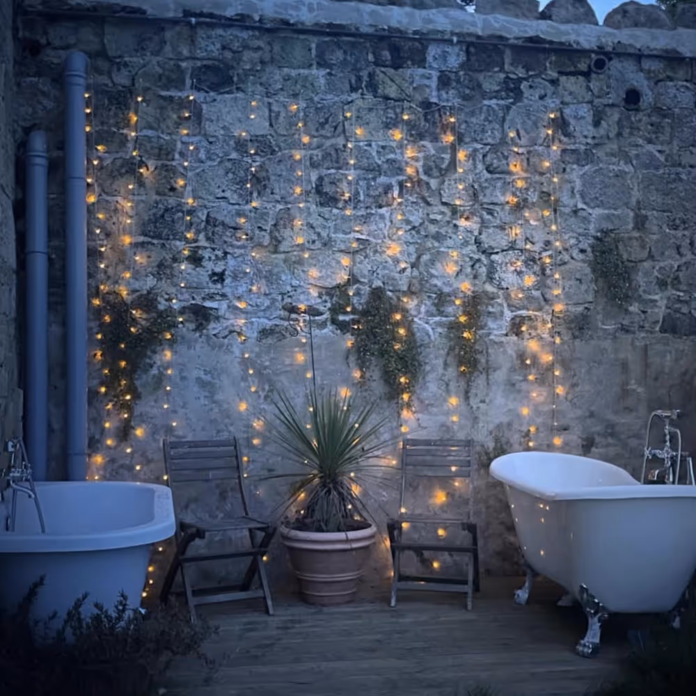 Outdoor twin baths lit with fairy lights