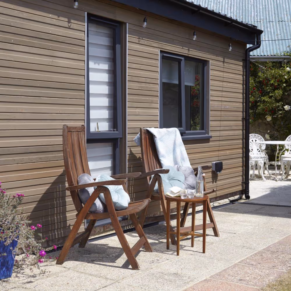 Two folding chairs outside a garden cabin
