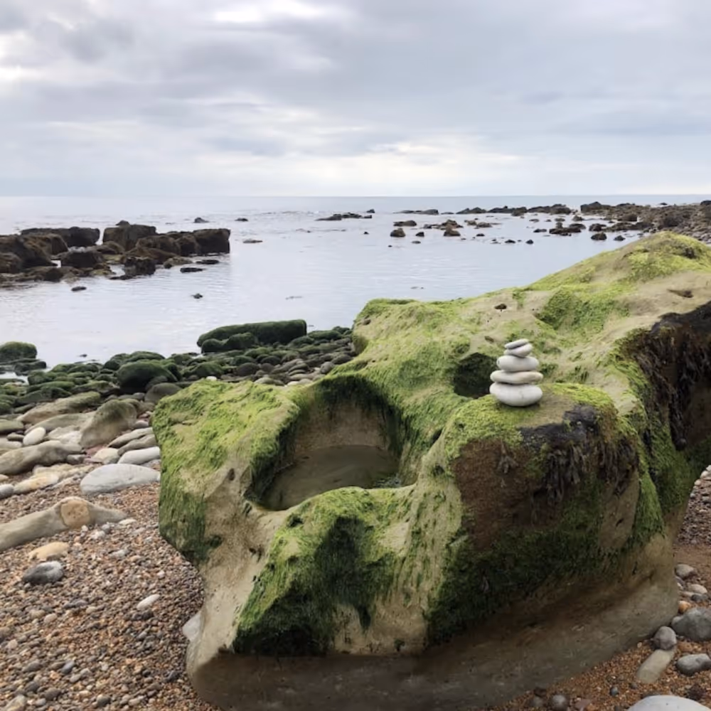 A coastal bay with large rocks on the beach