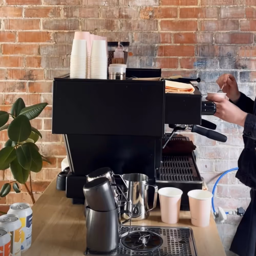 Someone operating a coffee machine in a cafe
