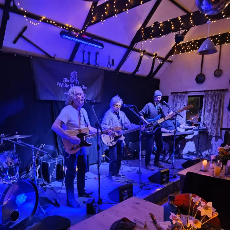 A band on a stage bathed in blue light