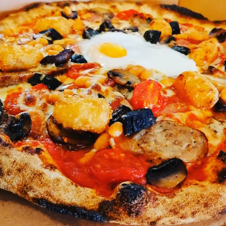 A stonebaked pizza with peppers spinach and egg