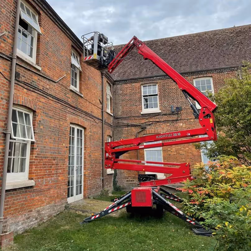 A cherry picker accessing the roof of a building