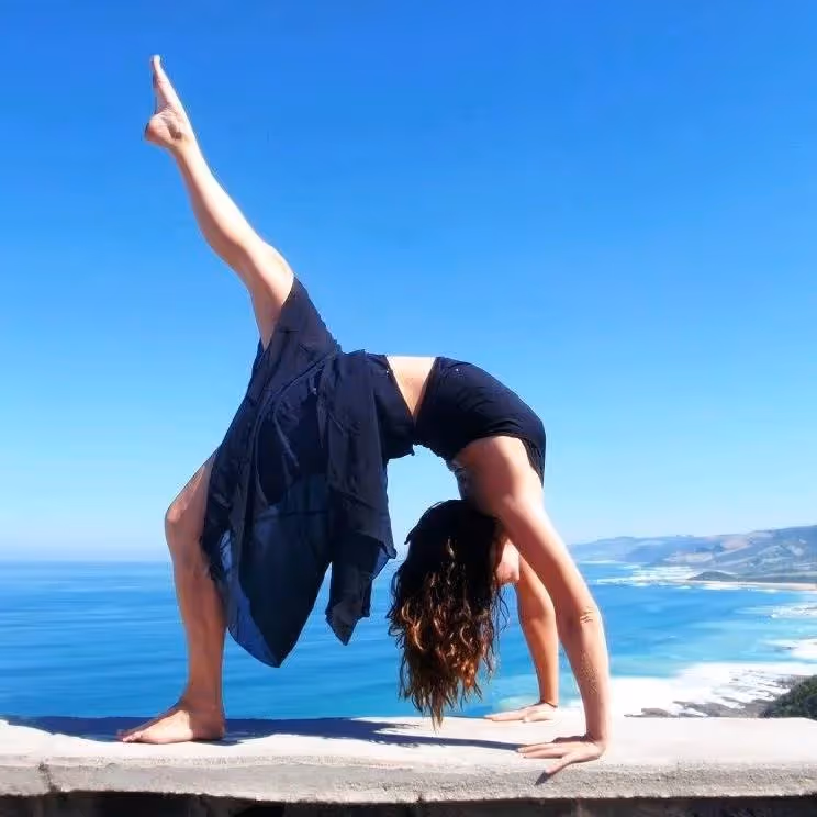 A lady in a yoga position overlooking the ocean