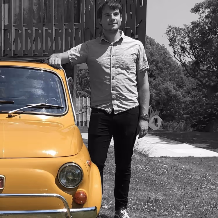 A man stood to the right of a yellow car
