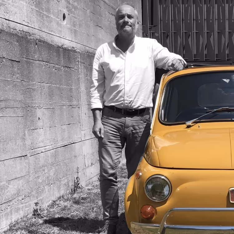 A man stood to the left of a yellow car