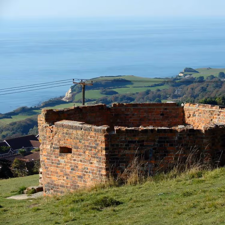 A red brick octagonal structure on a coastal hillside