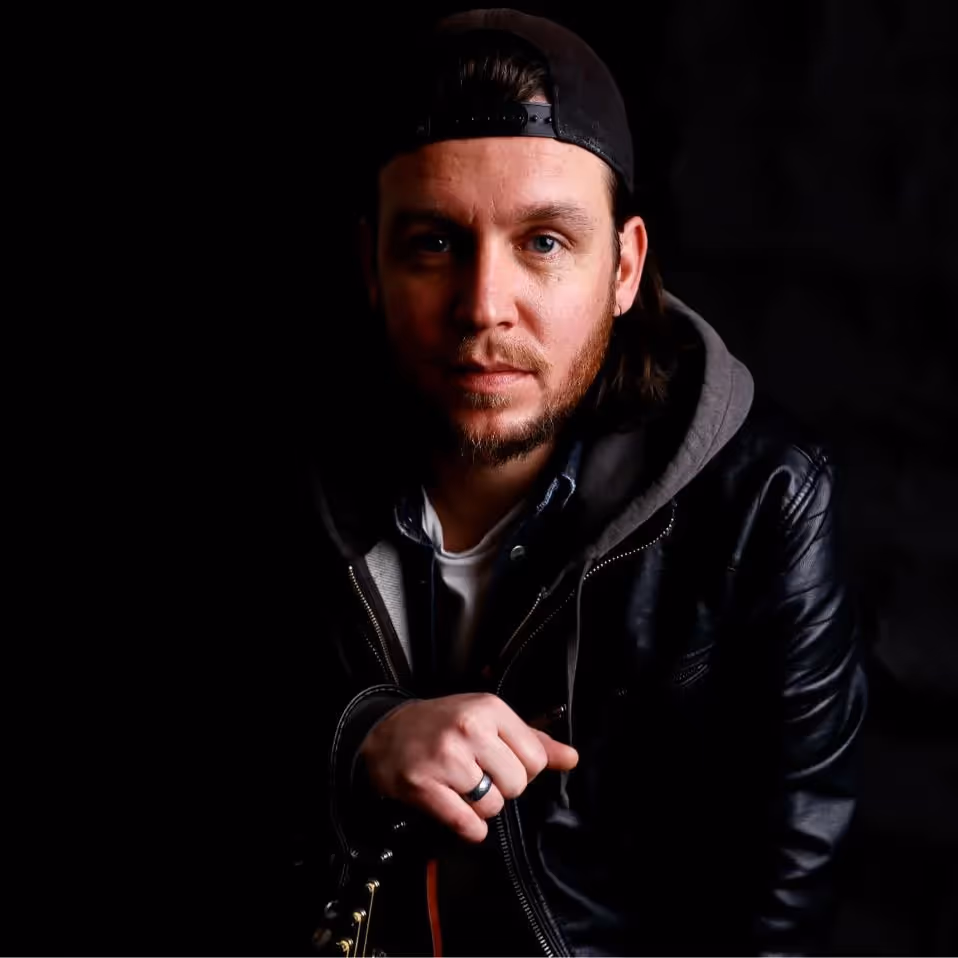 A moody photo of a musician with his guitar