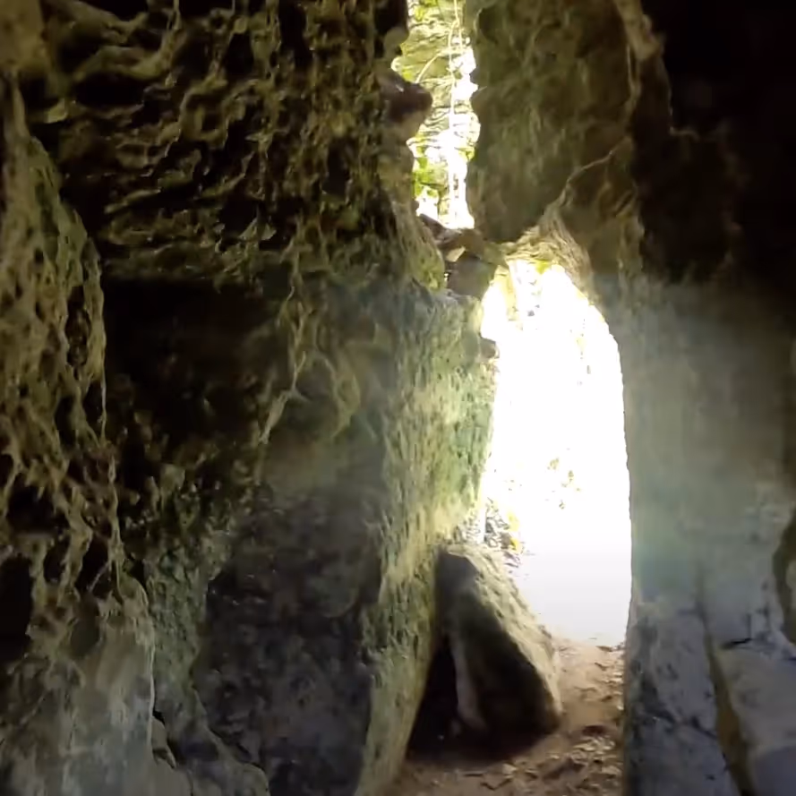 Inside a dark cave looking through to the day lit entrance