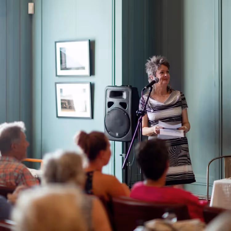 A woman performing to an audience in an arts club
