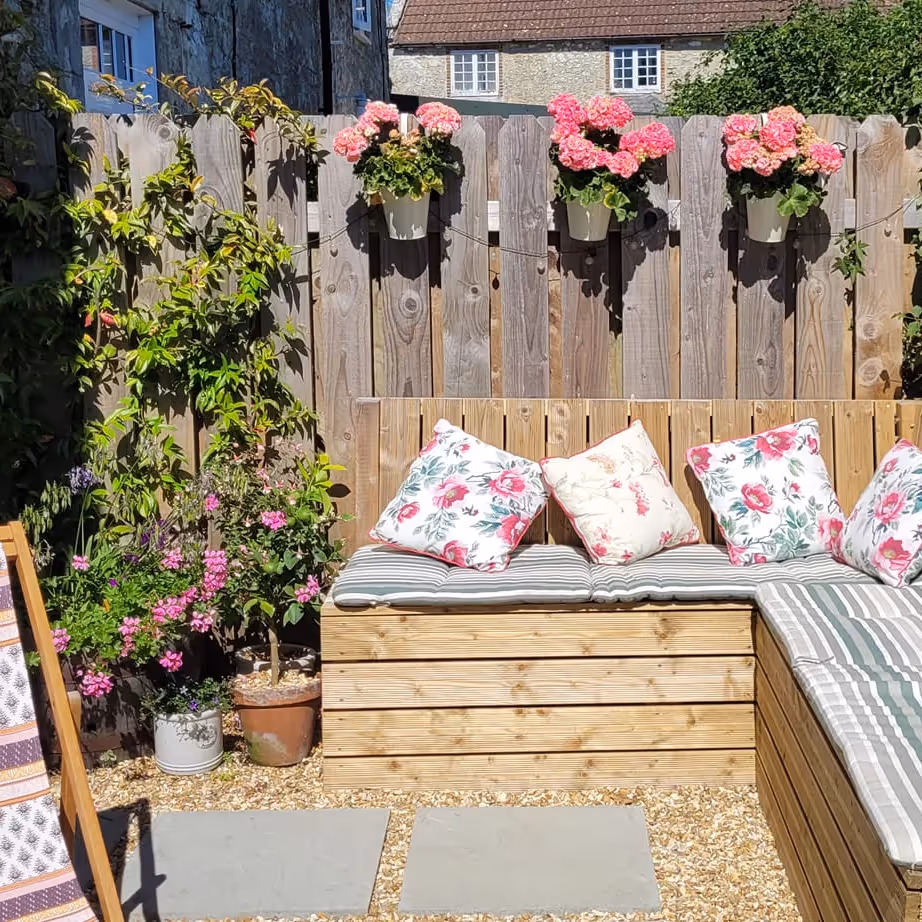 Outside seating with bench cushions and hanging baskets of flowers