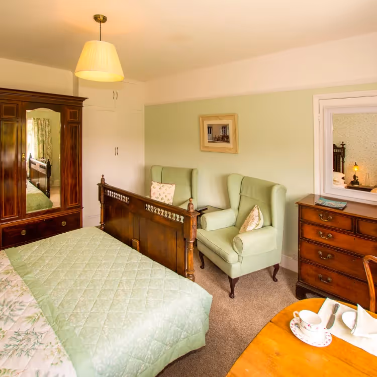 An elegant green bedroom with traditional furniture