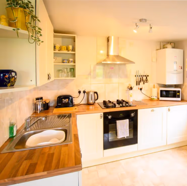 A cream shaker kitchen with wooden worktops