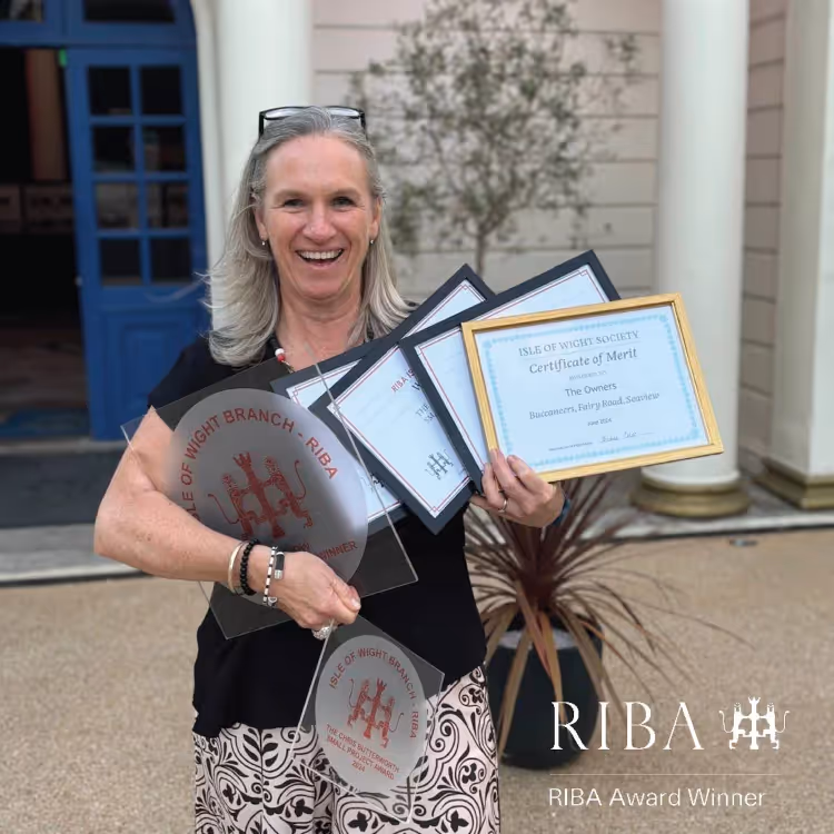 A lady holding framed award certificates