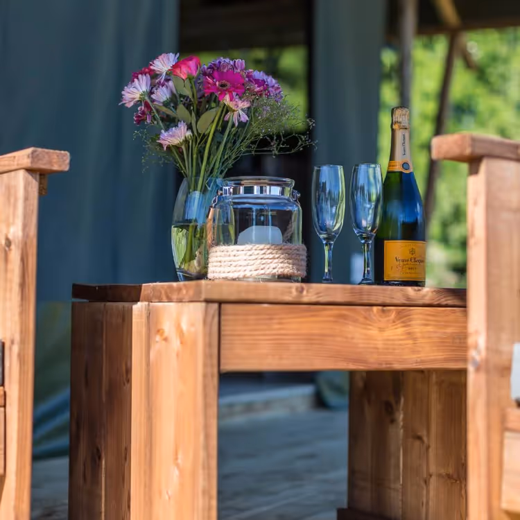 Flowers and champagne outside a glamping tent