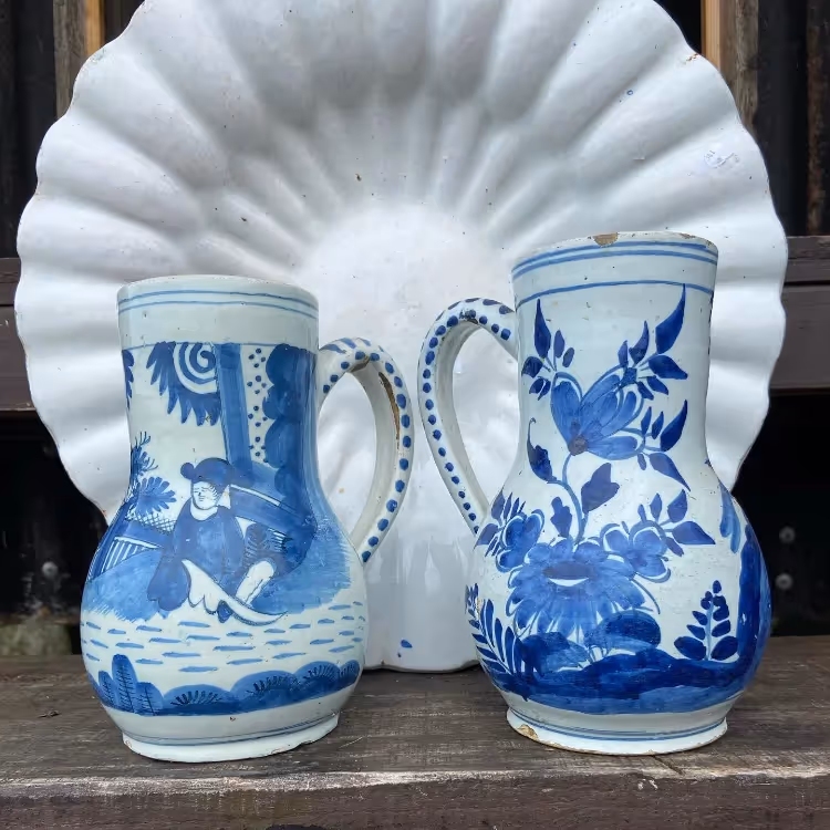 A white fluted plate and two blue and white ceramic jugs