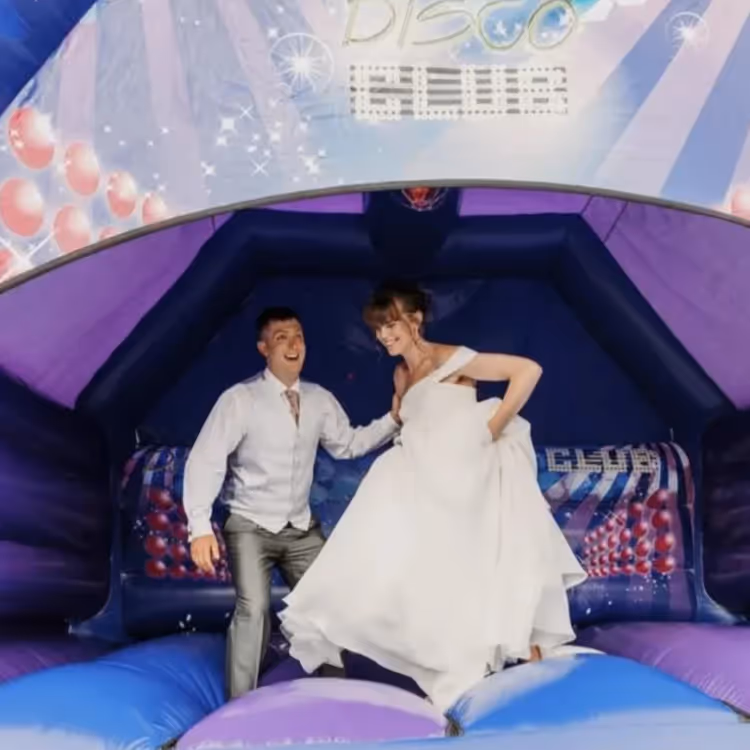 A bride and groom in a bouncy castle