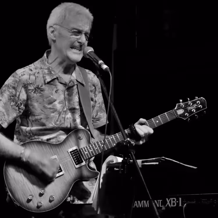 A man singing and playing electric guitar
