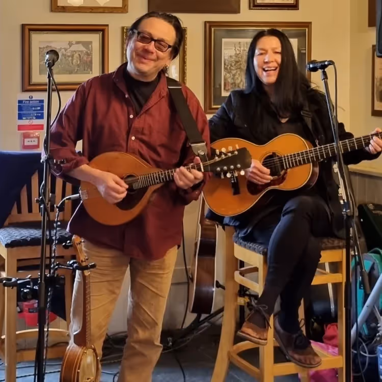 A man and woman playing guitars