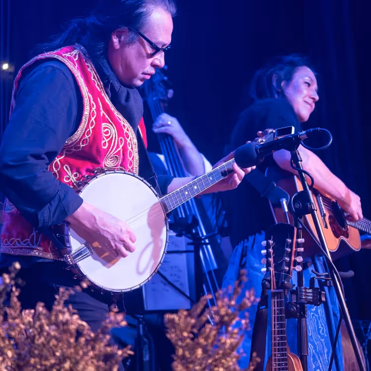 A man and woman performing music on a stage