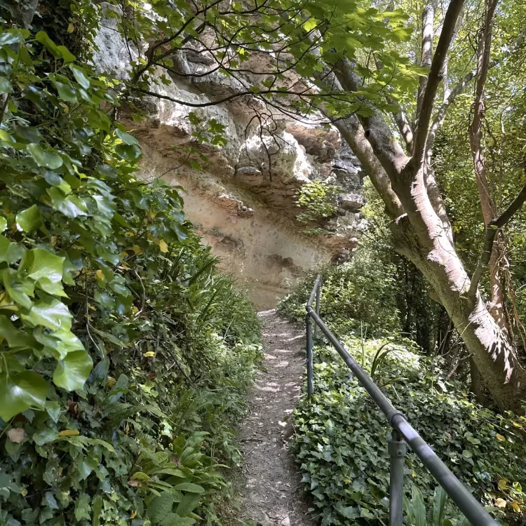 A steep path with metal railing leading up to a cliff face