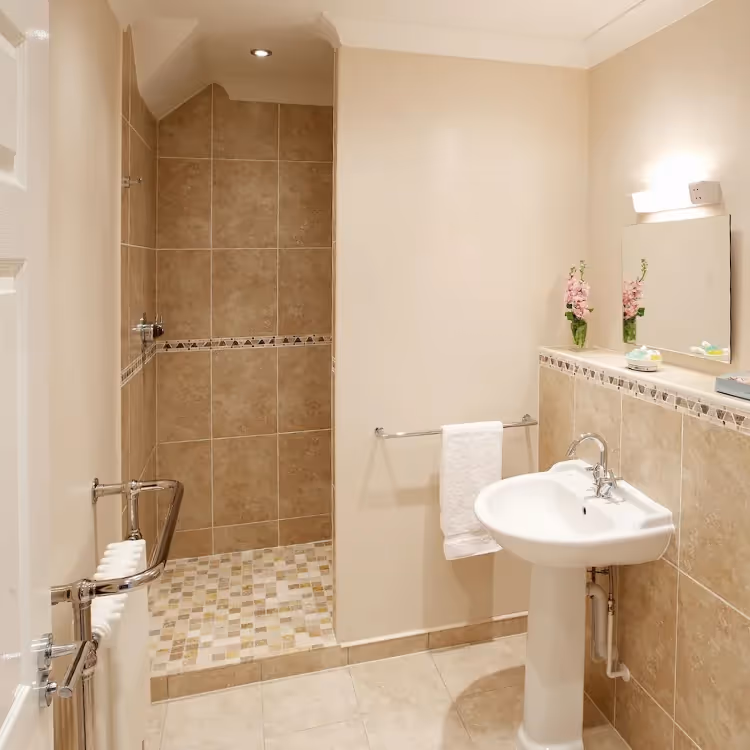A shower room with cream tiles