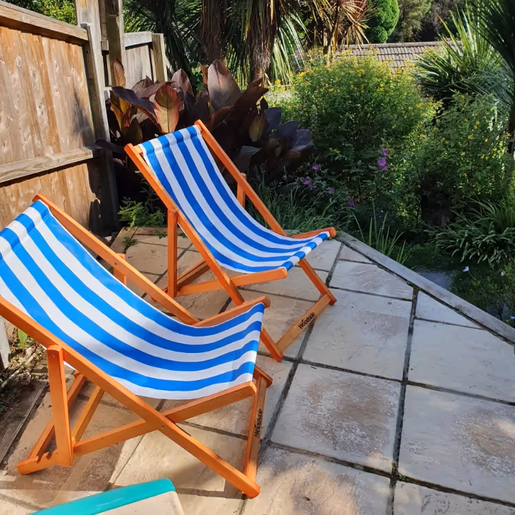 Two blue and white deckchairs in a garden