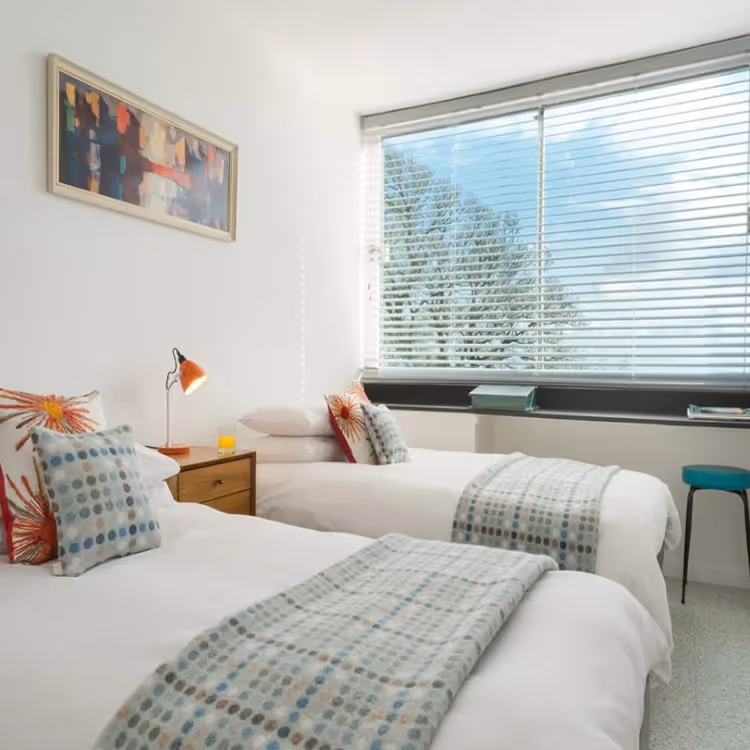 A modern twin bedroom with 1970s furniture
