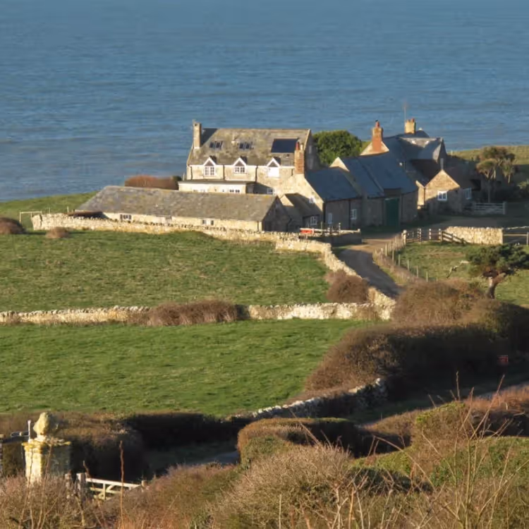 A cottage on the edge of a cliff with panoramic sea views