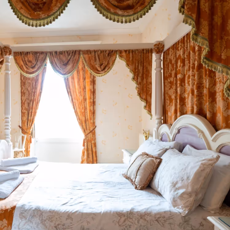 A four poster bed with swags and tails