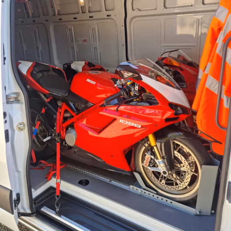Two motorbikes strapped into the load area of a van