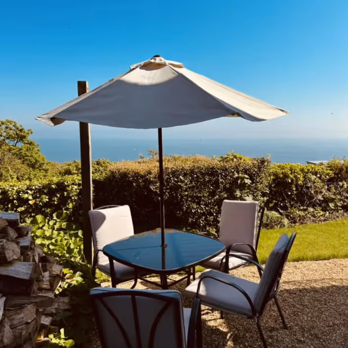 Patio furniture in a garden overlooking the sea