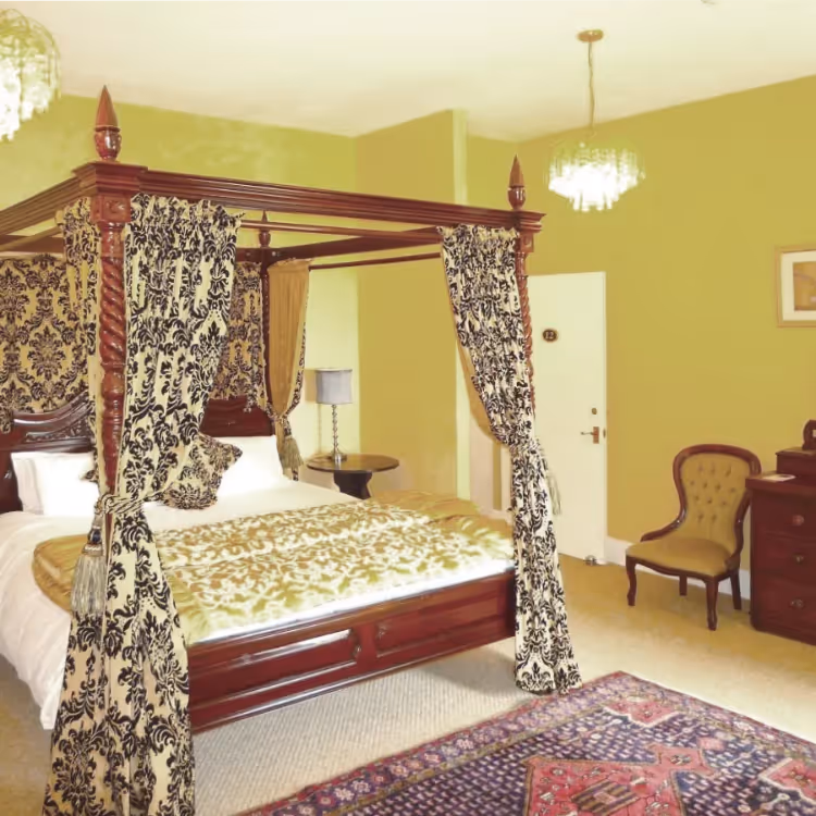 An elegant bedroom with a large four poster bed