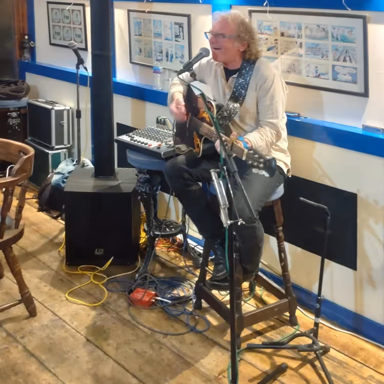 A man playing guitar in a pub