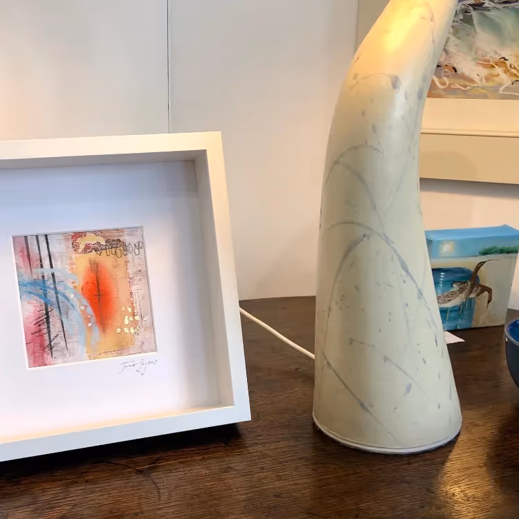 A framed picture on a table next to a sculpture