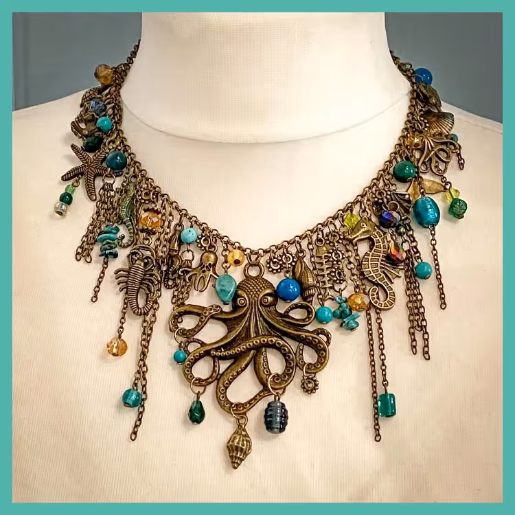 A handmade necklace adorned with green gemstones and sea creatures