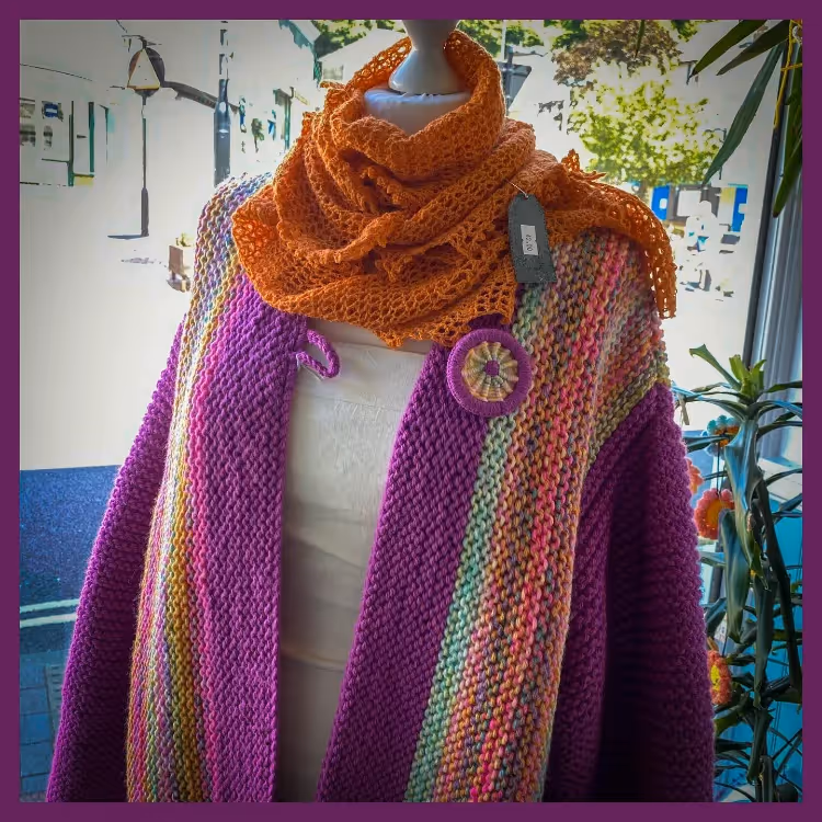 A crocheted scarf and shawl in purple and orange