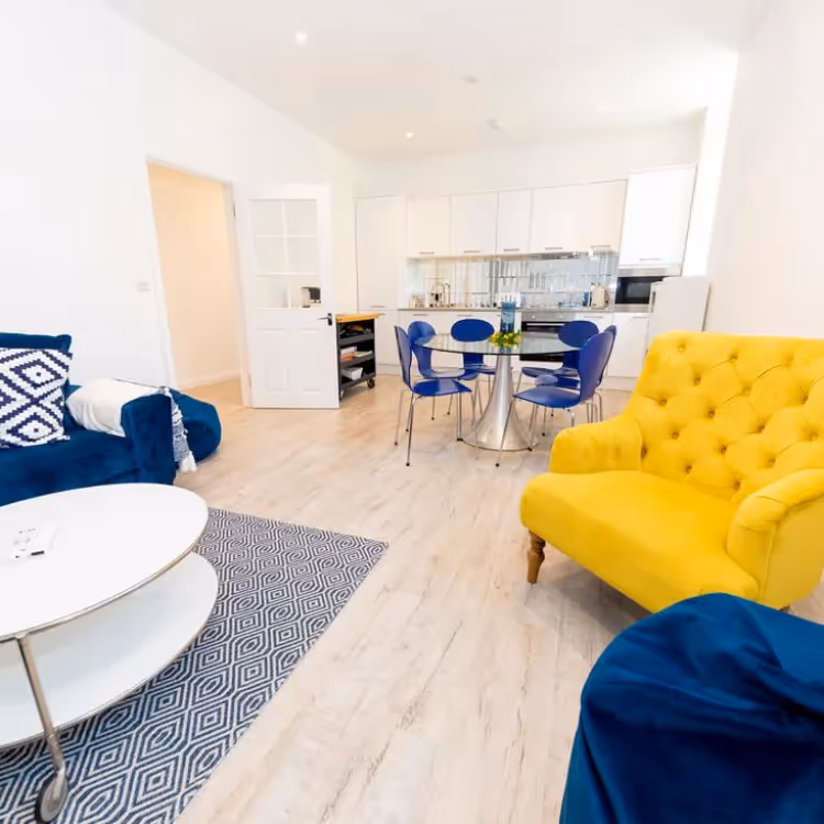 An open plan kitchen living dining room decorated in white blue and yellow