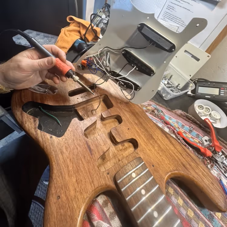 A man repairing an electric guitar
