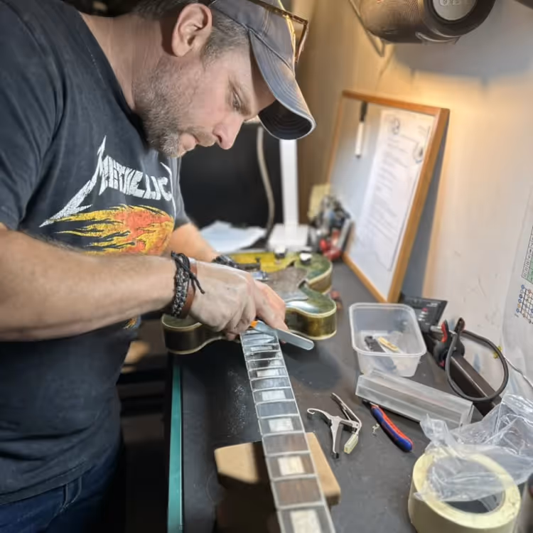 A man repairing an electric guitar