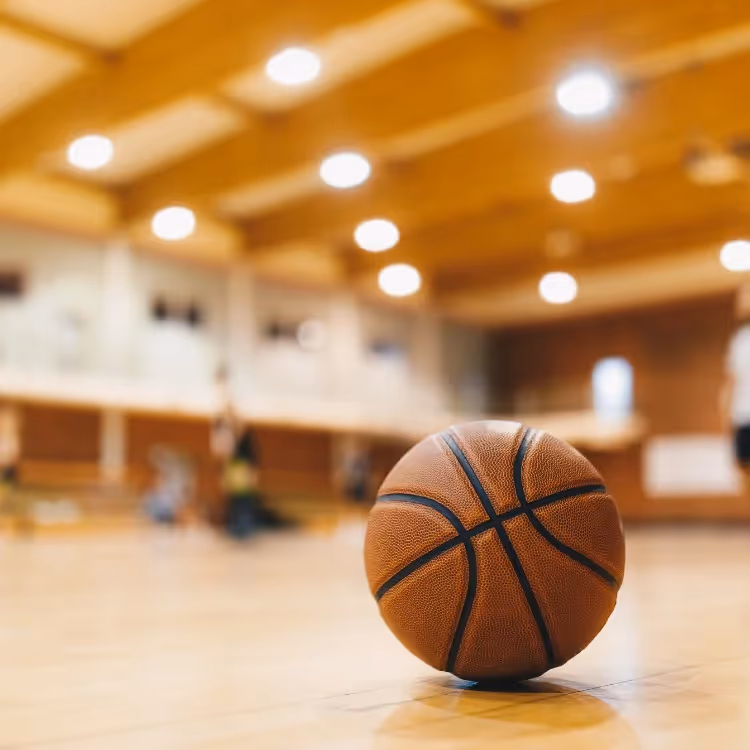 A basketball on the floor of a sports hall