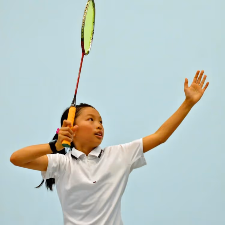A kid about to take a shot in a badminton game