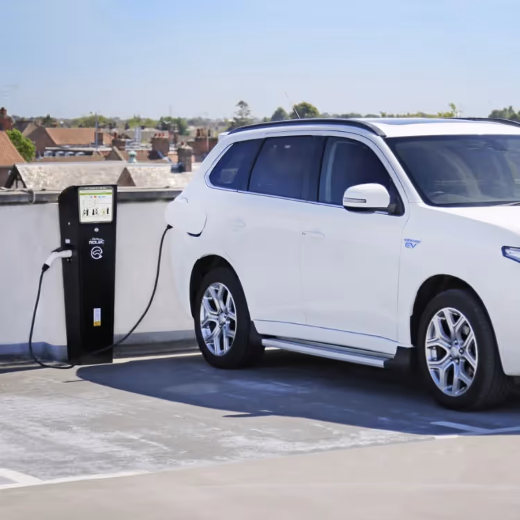 A white car plugged into an EV charger