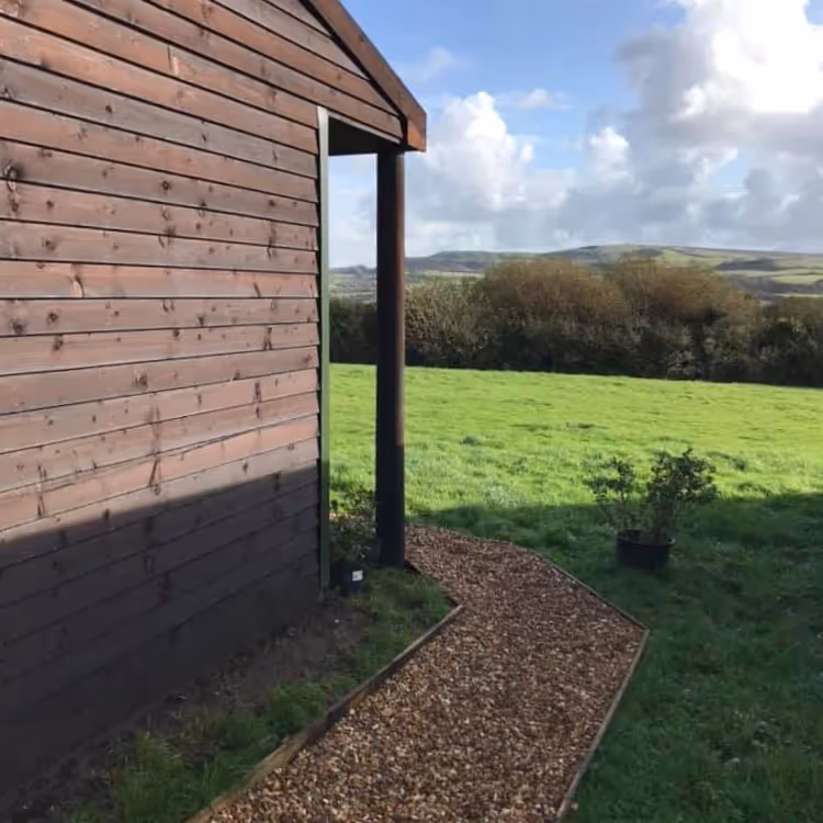 A wooden clad building in a field
