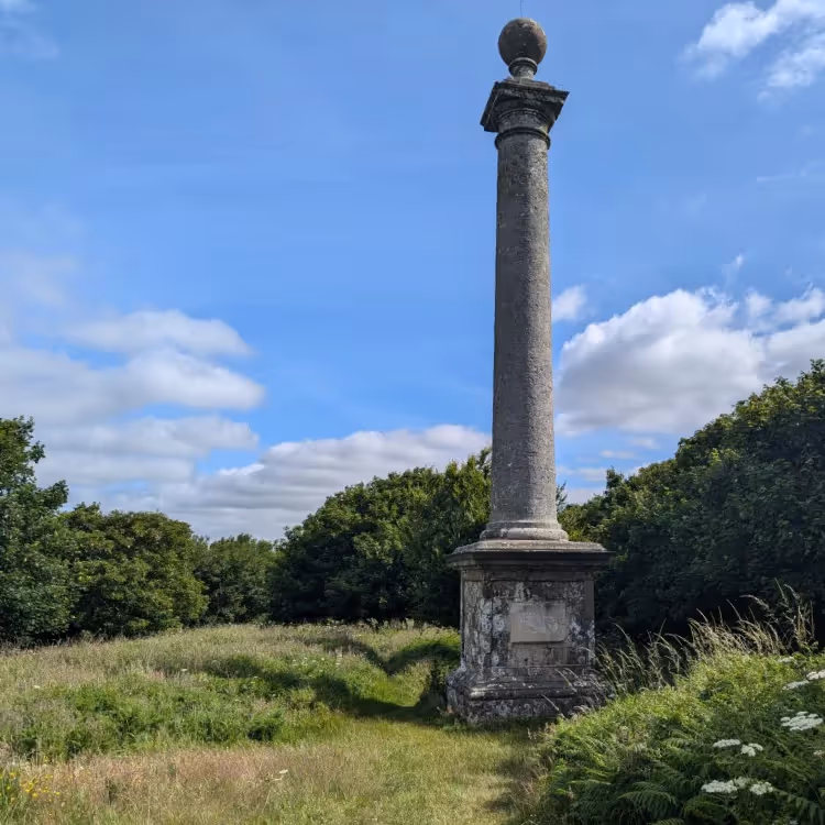 A tall stone monument in open countryside